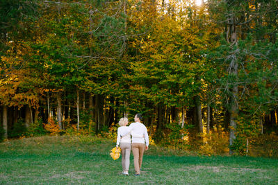 Rear view of people walking in forest