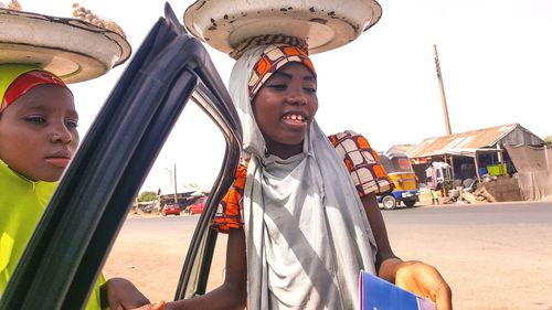 Low angle view of smiling young man standing at amusement park