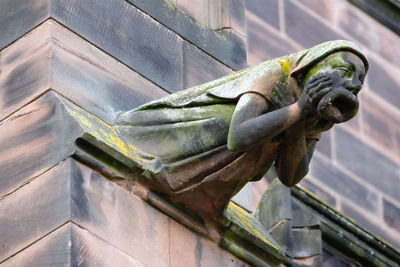 Low angle view of statue against old door