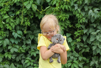 Cute little girl hugs her favorite toy gray kitten basik