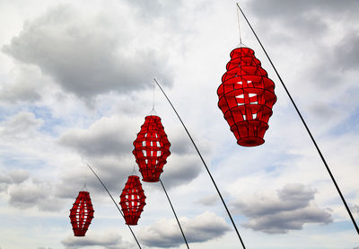 Low angle view of red lanterns hanging against sky