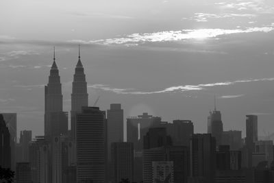 Skyscrapers in city against cloudy sky