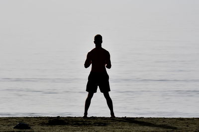 Rear view of man standing on beach