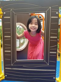 Portrait of smiling girl playing standing in jungle gym