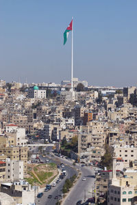 Road amidst buildings in city against clear sky