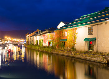 Canal amidst buildings in city at night