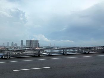 Bridge over road against sky in city