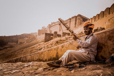 Man sitting in front of built structure
