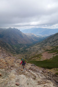 People riding motorcycle on mountain against sky