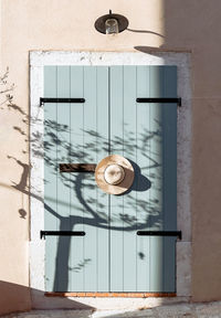 Hat hangin on old wooden door, pastel colored, neutrals.