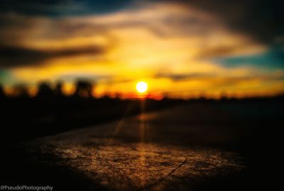 Close-up of road against orange sky during sunset