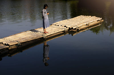 Woman standing on pier over lake
