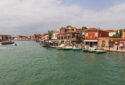 Houses by sea against sky in city