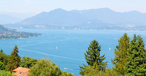 High angle view of townscape by sea against mountains