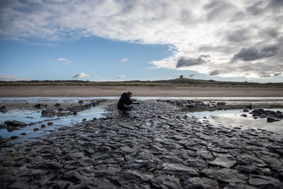 Rear view of person on beach against sky