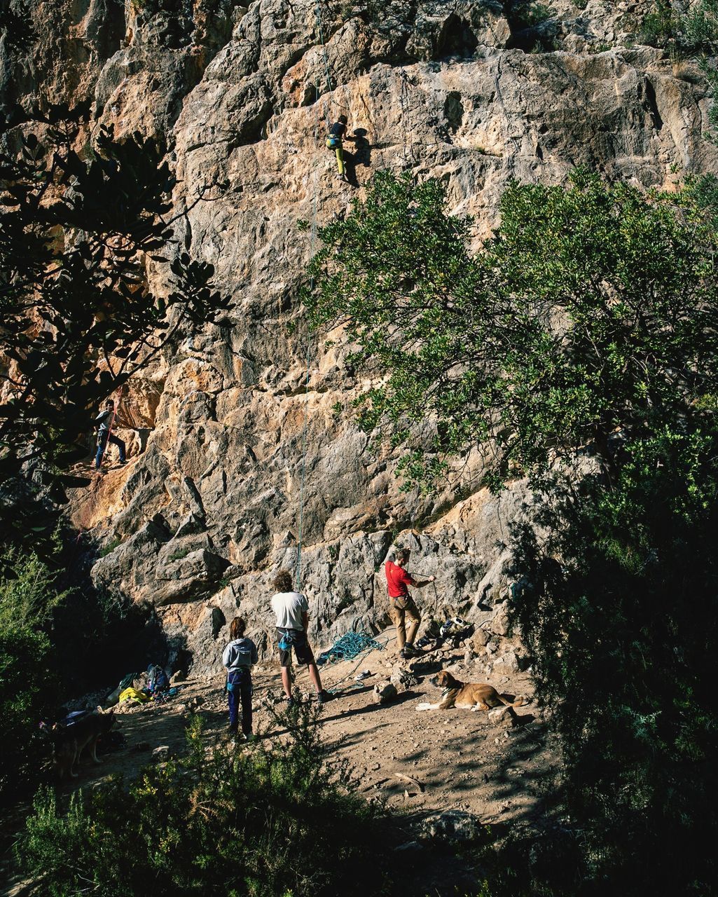 PEOPLE WALKING ON ROCKS AGAINST MOUNTAINS