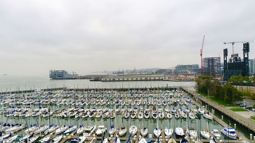 Aerial view of city by sea against sky