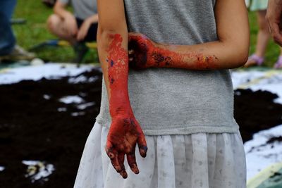 Midsection of messy woman standing on field