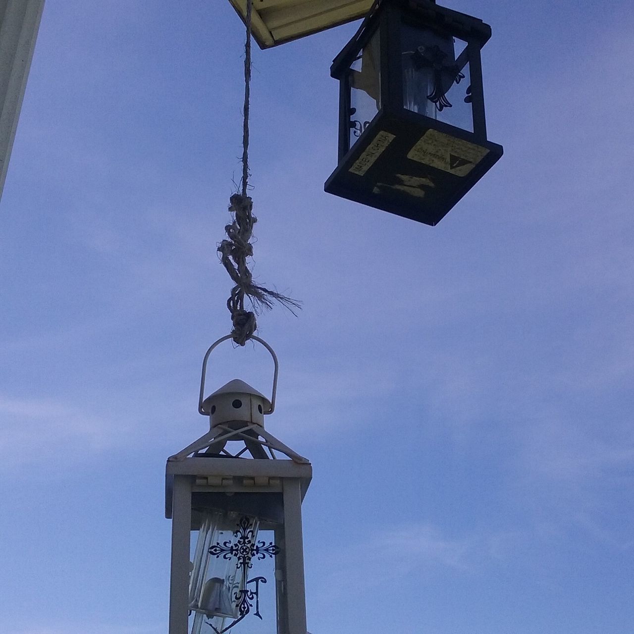 low angle view, built structure, architecture, building exterior, sky, lighting equipment, human representation, street light, blue, religion, cross, day, high section, clock, no people, outdoors, church, clear sky, sculpture