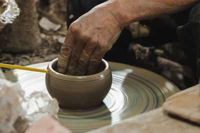 Cropped hands of man making pot