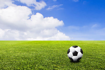 Scenic view of soccer ball on field against sky