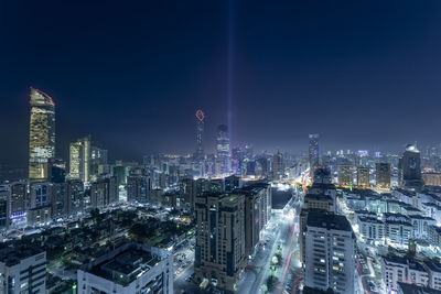 Illuminated buildings in city against sky at night