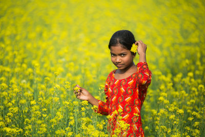 Portrait of smiling girl standing on field