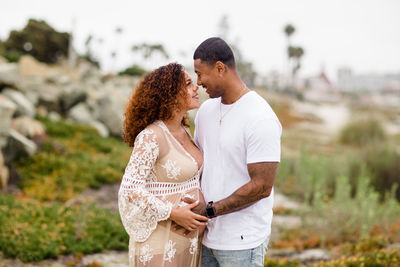 Mixed race couple looking at one another on beach