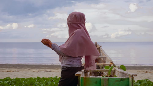 Rear view of man standing on beach