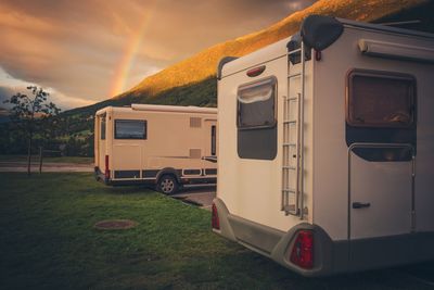 Camper van on field against sky during sunset