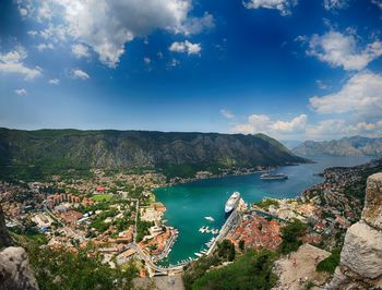 High angle view of bay and cityscape against blue sky