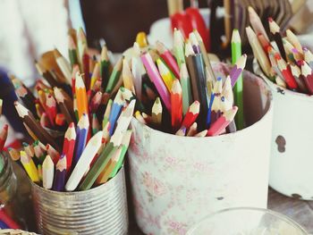 Close-up of colorful pencils in containers on table