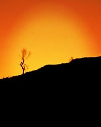 Silhouette landscape against clear sky during sunset