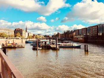 Boats moored in city against sky