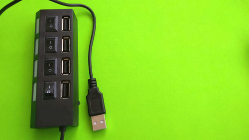 High angle view of telephone on table against green background