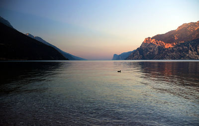 Scenic view of sea and mountains at sunset