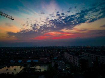 Aerial view of illuminated city at sunset