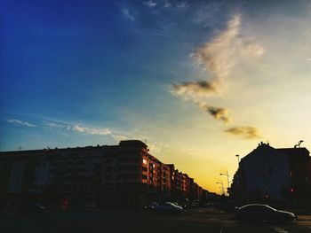City street against sky at sunset