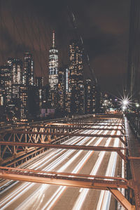 Illuminated modern buildings in city against sky at night