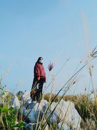 Rear view of man on field against clear sky