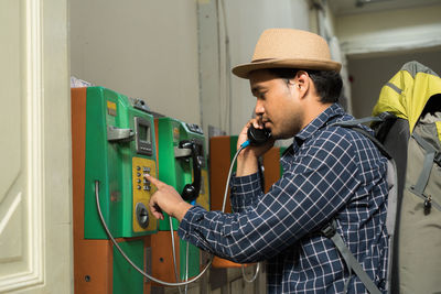 Side view of man using telephone