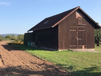 Barn on field against clear sky