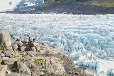 People standing on rock by mountain