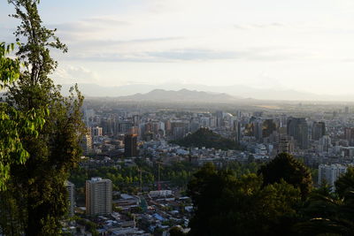 View of cityscape against cloudy sky