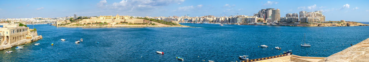 Panoramic view of sea and buildings against sky