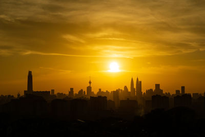 View of buildings against cloudy sky during sunset