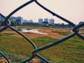 Cityscape seen through chainlink fence