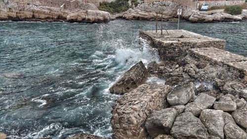 Rock formation in sea against sky