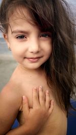 Portrait of shirtless girl with hand on chest while standing outdoors