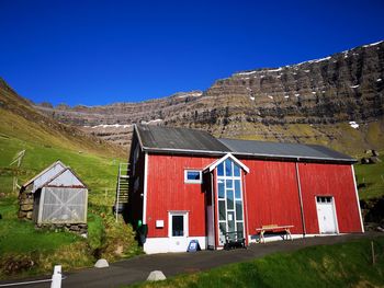 Houses on mountain against clear blue sky